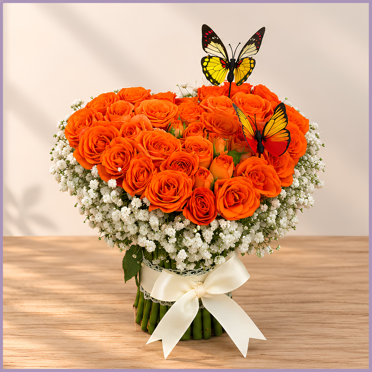 Orange Burst heart-shaped arrangement with orange spray roses, gypsophila and two butterfly accents – Jude Flowers Bahrain